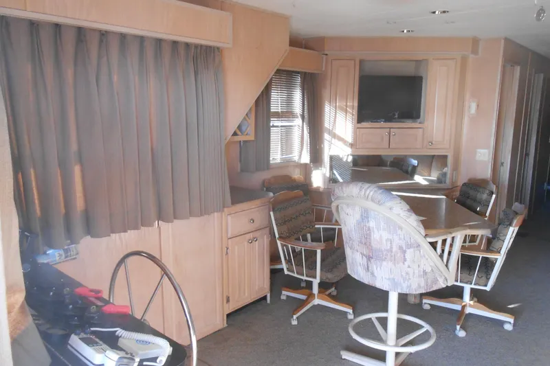 Slide: The Image of Interior of a 1993 Stardust Cruisers 5715 houseboat with dining area and TV. - 4
