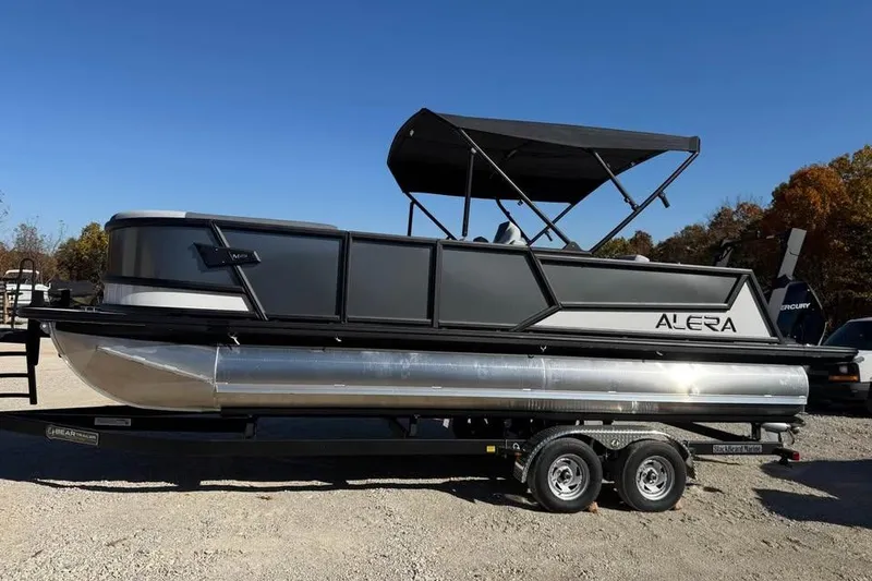 The Image of 2026 Alera M 23L pontoon boat on trailer under clear blue sky. - 0