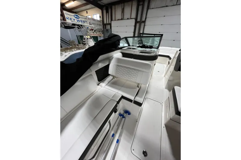 Slide: The Image of 2021 Sea Ray SDX 270 Outboard interior with white seating and windshield in showroom. - 16