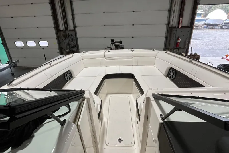 Slide: The Image of 2021 Sea Ray SDX 270 Outboard boat interior with white seating in a garage. - 19