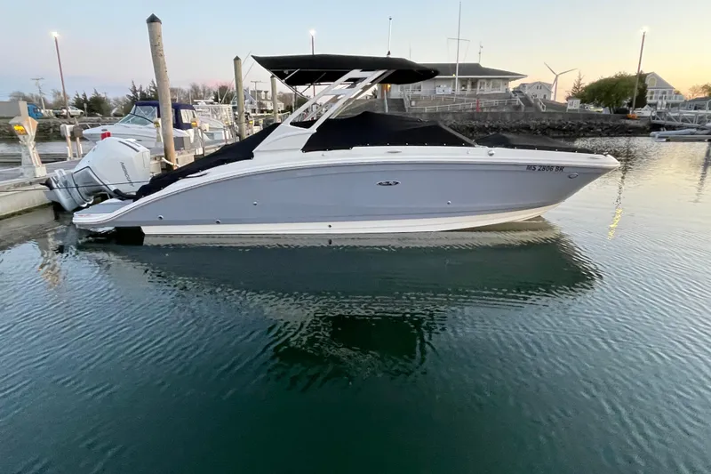 Slide: The Image of 2021 Sea Ray SDX 270 Outboard boat docked at marina during sunset. - 2