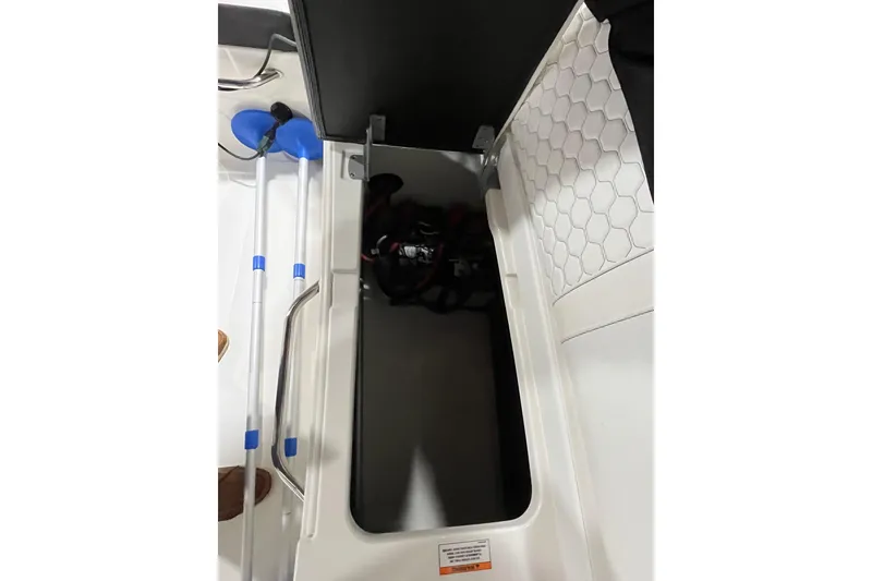 Slide: The Image of 2021 Sea Ray SDX 270 Outboard storage compartment with paddles and equipment. - 24