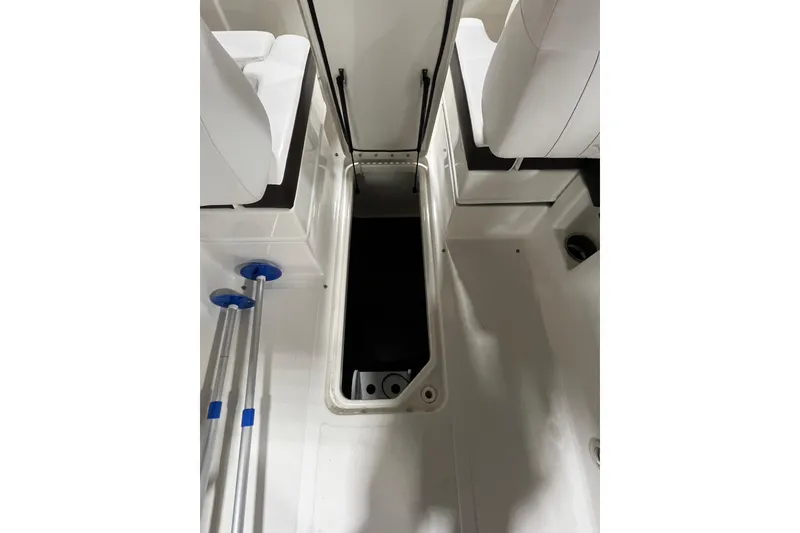 Slide: The Image of 2021 Sea Ray SDX 270 Outboard interior storage compartment with white seating and accessories. - 25