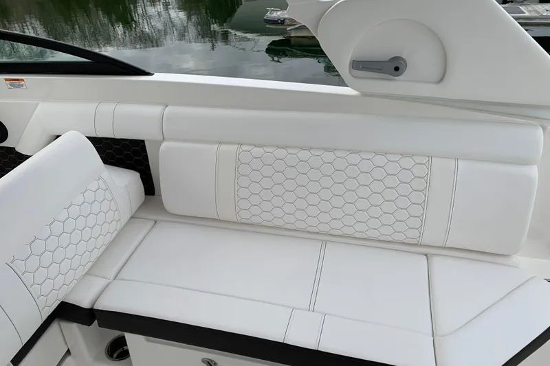 Slide: The Image of 2021 Sea Ray SDX 270 Outboard boat interior with white cushioned seating. - 31