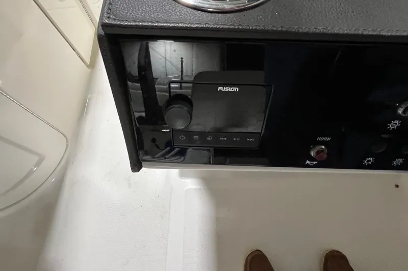 Slide: The Image of 2021 Sea Ray SDX 270 Outboard dashboard with Fusion audio system and horn button. - 33