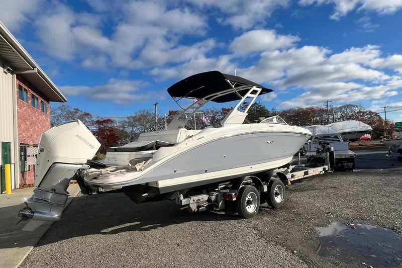 Slide: The Image of 2021 Sea Ray SDX 270 Outboard boat on trailer, parked outdoors under a blue sky. - 4