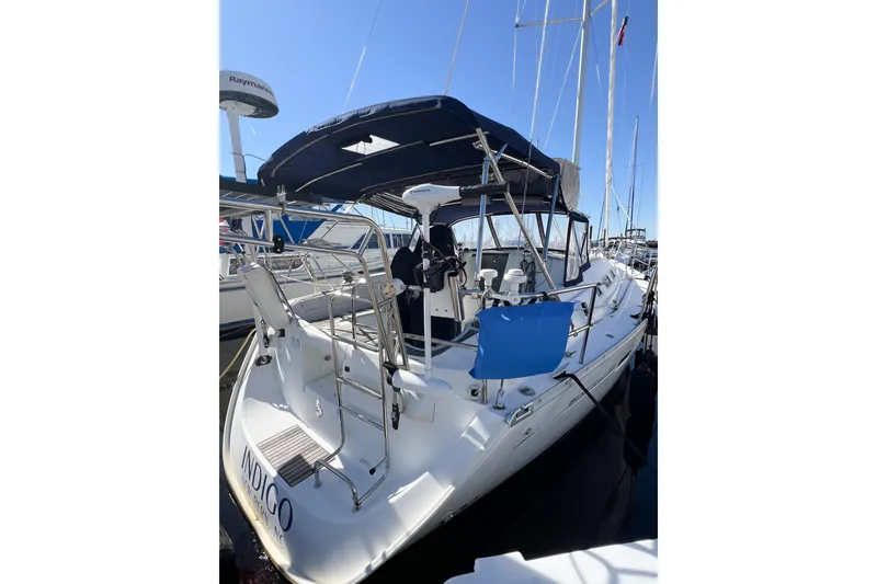 Slide: The Image of 2007 Beneteau 373 sailboat docked, featuring a spacious cockpit and blue canopy. - 10