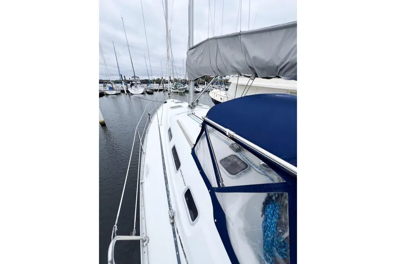 Slide: The Image of 2007 Beneteau 373 sailboat docked in marina, featuring sleek design and blue canopy. - 18
