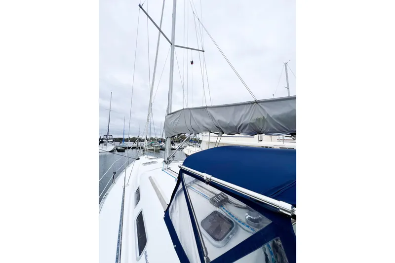 Slide: The Image of 2007 Beneteau 373 sailboat with blue canopy and docked mast, overcast sky. - 19