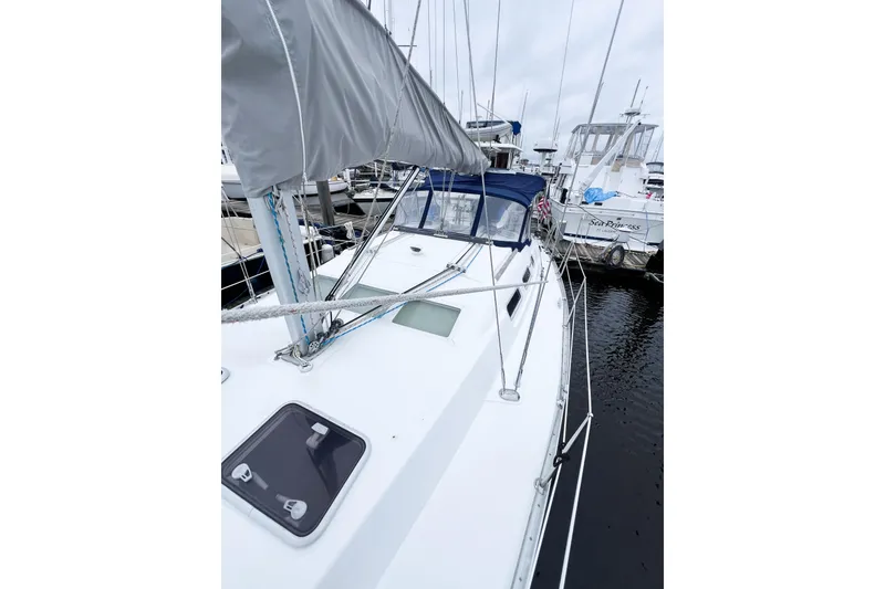 Slide: The Image of 2007 Beneteau 373 sailboat docked at marina, featuring sleek design and covered sails. - 23