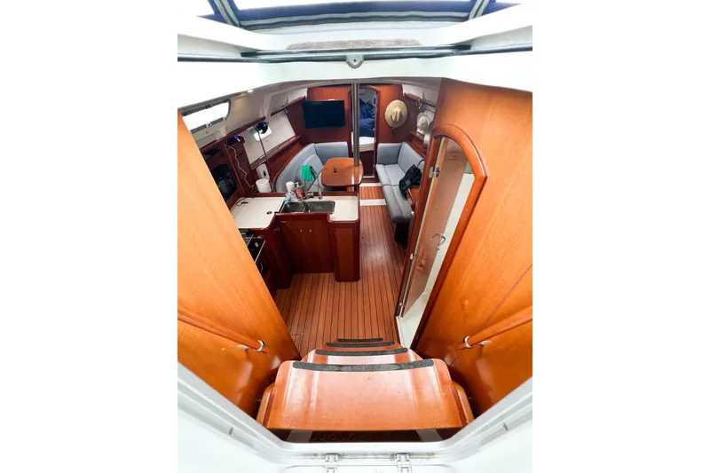 Slide: The Image of Interior of 2007 Beneteau 373 sailboat, featuring wood finishes and cozy seating area. - 35