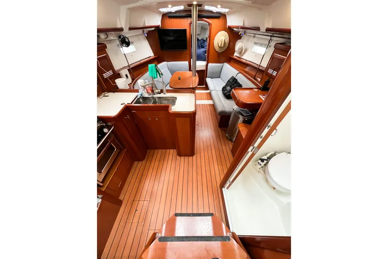 Slide: The Image of 2007 Beneteau 373 yacht interior with wood finish, kitchen, seating, and bathroom. - 37