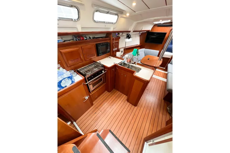 Slide: The Image of Interior of 2007 Beneteau 373 sailboat with kitchen and seating area. - 38