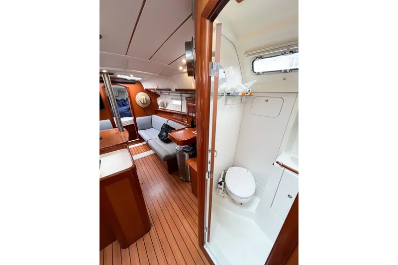 Slide: The Image of Interior of 2007 Beneteau 373 sailboat with wooden flooring and compact bathroom. - 39