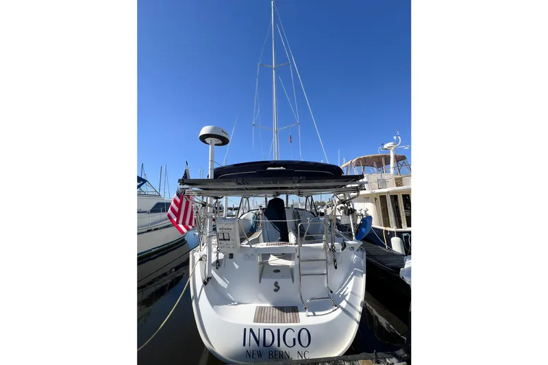 Slide: The Image of 2007 Beneteau 373 sailboat docked, rear view with American flag, clear sky. - 4