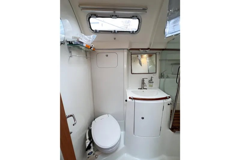 Slide: The Image of Bathroom interior of 2007 Beneteau 373 sailboat, featuring toilet, sink, and window. - 43