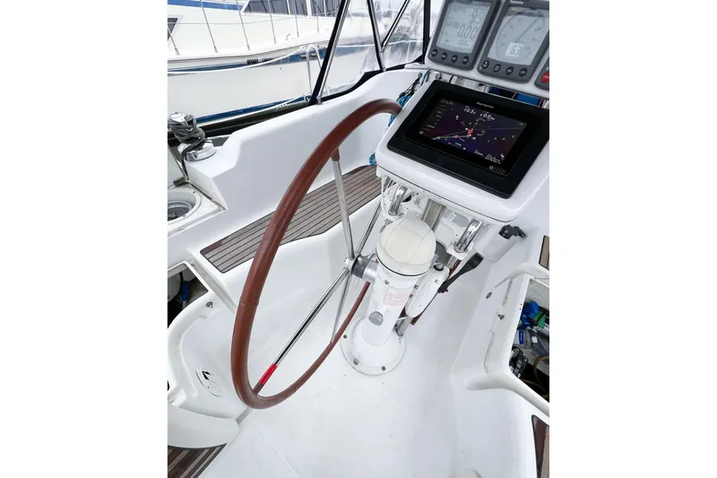 Slide: The Image of 2007 Beneteau 373 sailboat cockpit with navigation instruments and wooden steering wheel. - 50