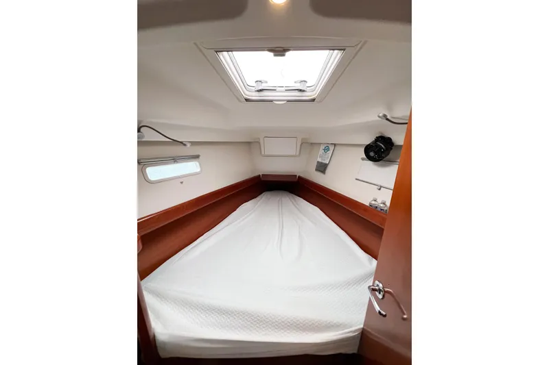 Slide: The Image of 2007 Beneteau 373 cabin interior with bed, wooden accents, and overhead hatch. - 61