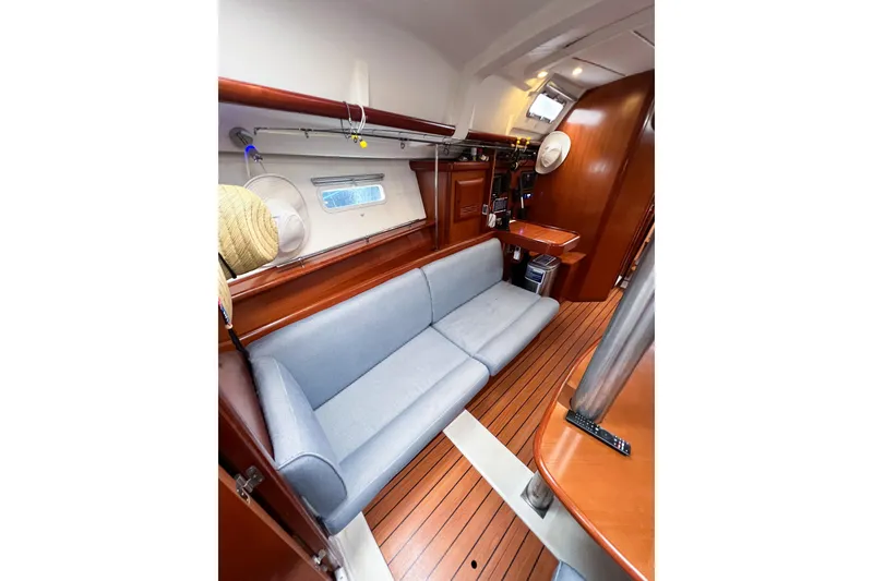 Slide: The Image of Interior of 2007 Beneteau 373 sailboat with wooden flooring and blue sofa. - 65