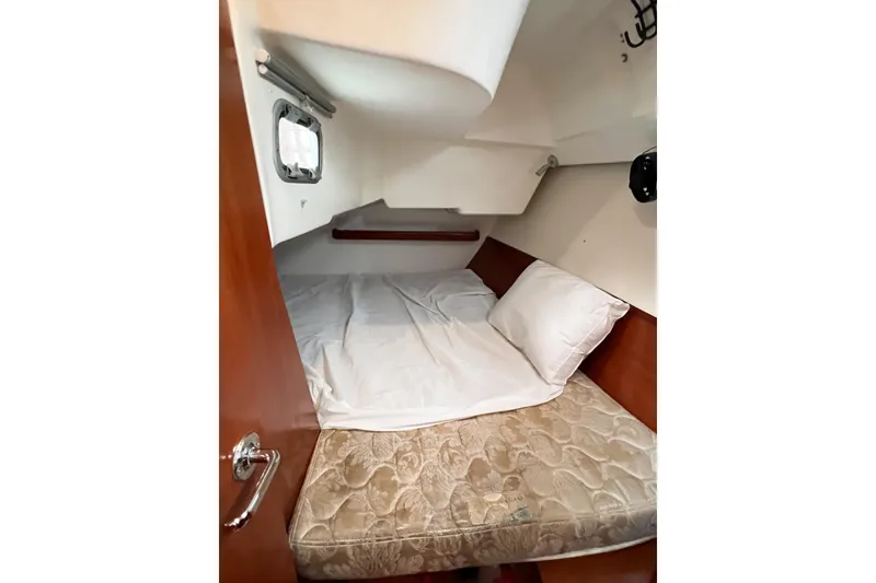 Slide: The Image of Cozy cabin interior of 2007 Beneteau 373 sailboat with bed and porthole. - 67