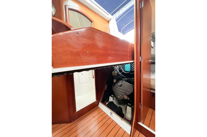 Slide: The Image of 2007 Beneteau 373 sailboat engine compartment with wooden interior and visible engine. - 75