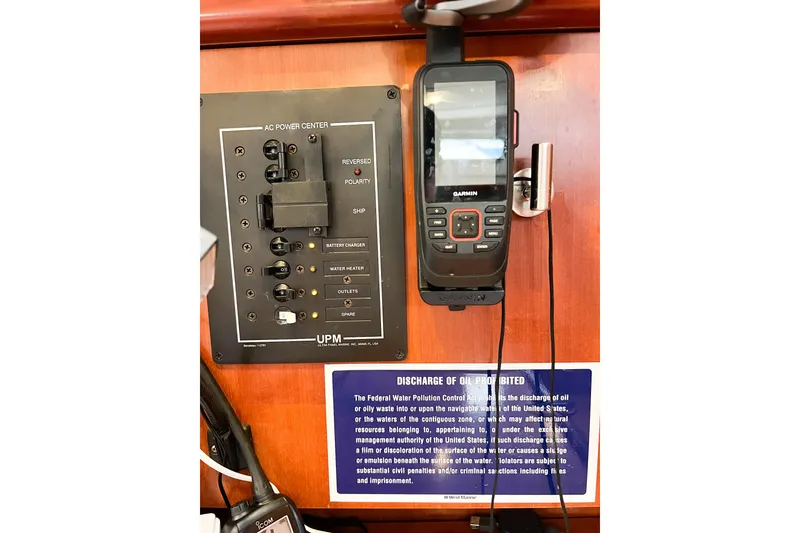 Slide: The Image of AC power panel and Garmin device on 2007 Beneteau 373 sailboat interior. - 80