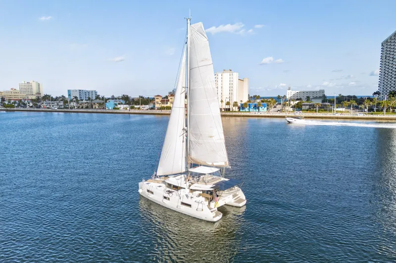 Slide: The Image of 2021 Lagoon 46 Owner's Version catamaran sailing near urban waterfront. - 110