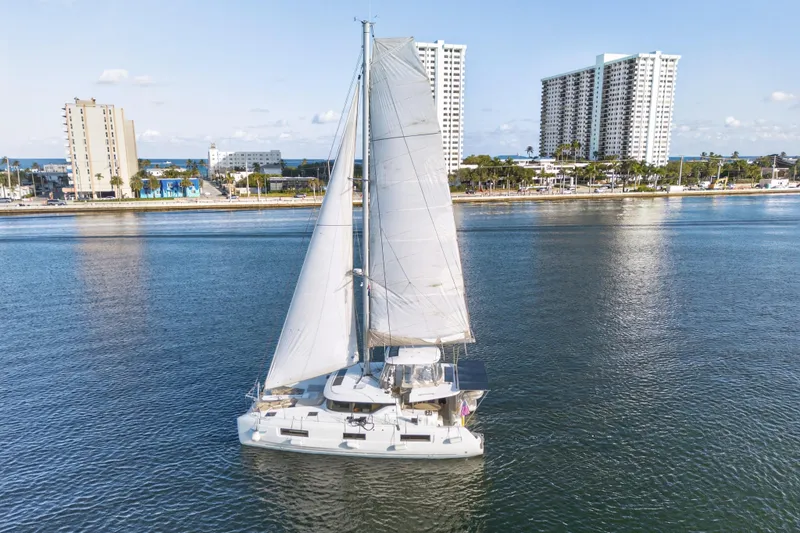 Slide: The Image of Sailing catamaran Lagoon 46 Owner's Version 2021 on calm waters near urban skyline. - 111
