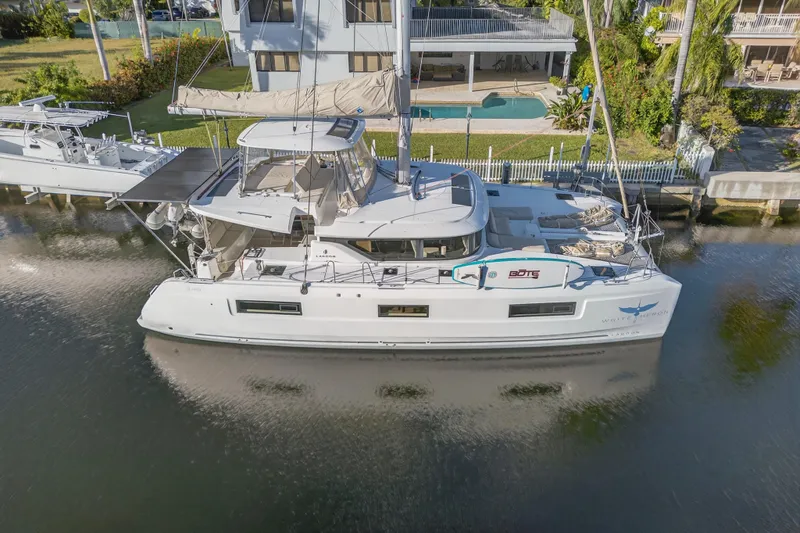 Slide: The Image of 2021 Lagoon 46 Owner's Version catamaran docked by waterfront property. - 118