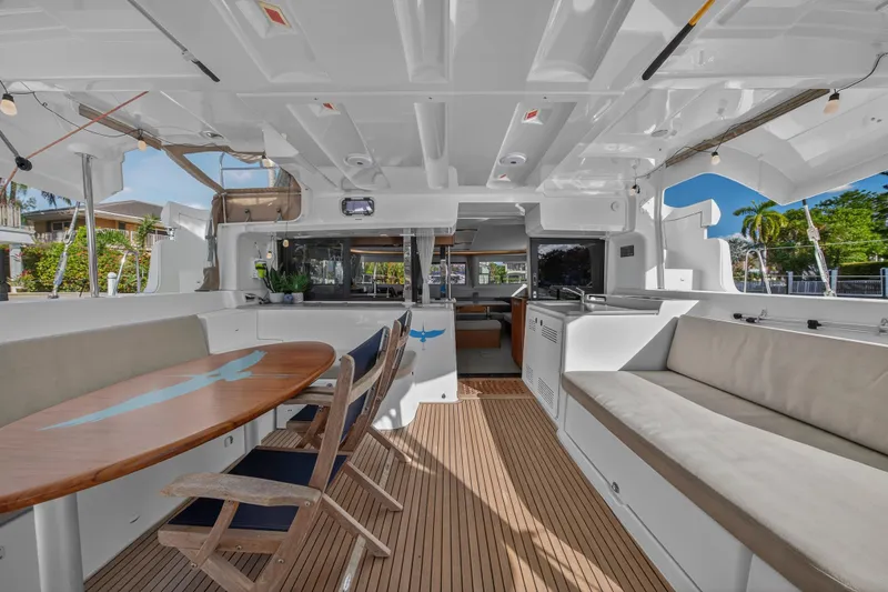 Slide: The Image of Spacious interior of 2021 Lagoon 46 Owner's Version catamaran with elegant seating and dining area. - 12