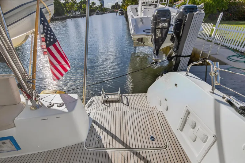Slide: The Image of Lagoon 46 Owner's Version 2021 yacht with American flag, docked by a serene canal. - 21