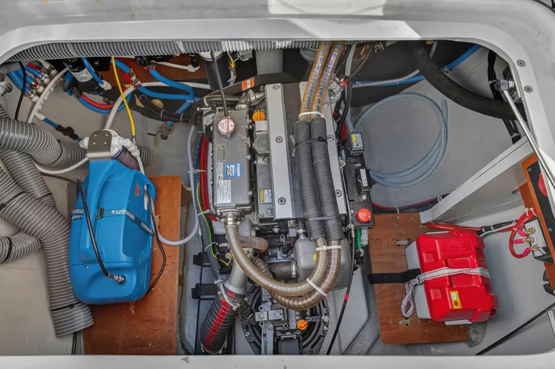 Slide: The Image of Engine compartment of 2021 Lagoon 46 Owner's Version catamaran, showcasing mechanical components and wiring. - 25