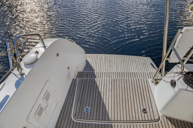 Slide: The Image of Sleek deck of 2021 Lagoon 46 Owner's Version catamaran on calm water. - 26
