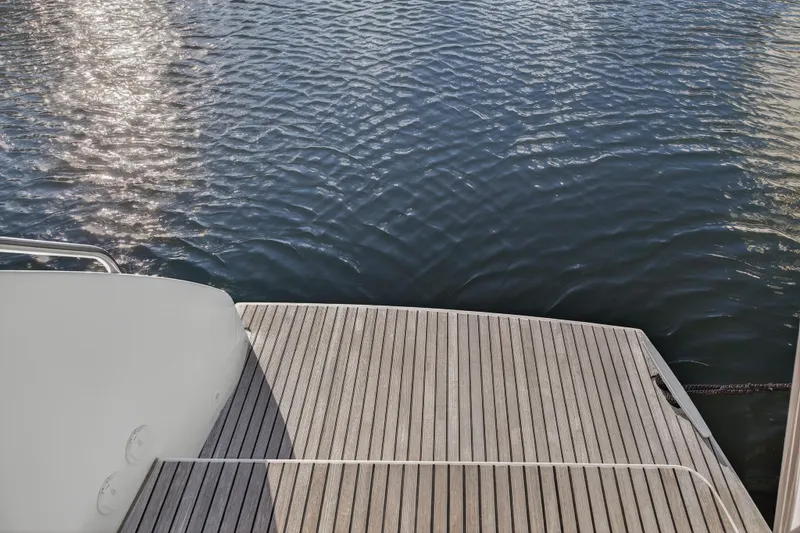 Slide: The Image of Lagoon 46 Owner's Version 2021 yacht deck overlooking calm water. - 27