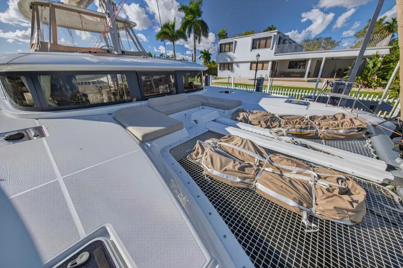 Slide: The Image of 2021 Lagoon 46 Owner's Version catamaran docked, featuring spacious deck and netting. - 40