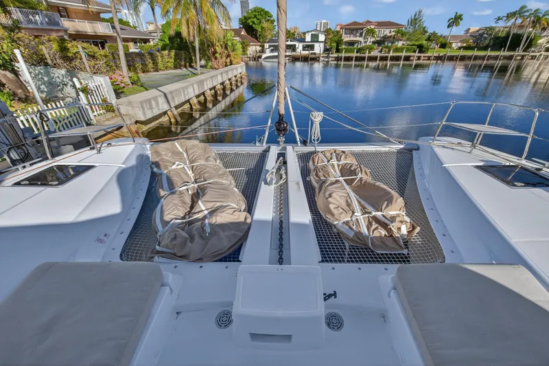 Slide: The Image of Lagoon 46 Owner's Version 2021 catamaran docked by a serene waterfront. - 42