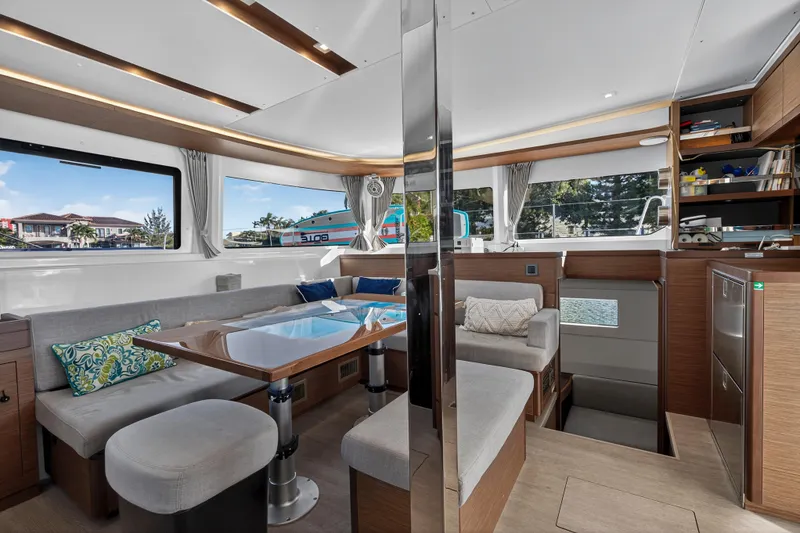 Slide: The Image of Luxurious interior of 2021 Lagoon 46 Owner's Version catamaran with modern furnishings and large windows. - 52