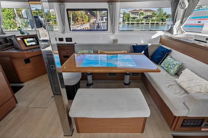 Slide: The Image of Luxurious interior of 2021 Lagoon 46 Owner's Version catamaran with modern seating and navigation area. - 53