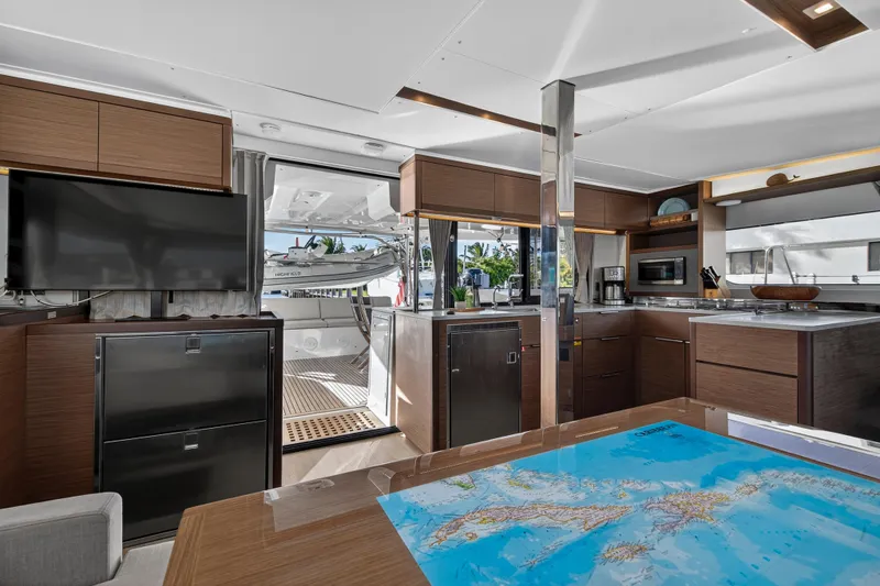 Slide: The Image of Luxurious interior of 2021 Lagoon 46 Owner's Version yacht with modern kitchen and map table. - 54