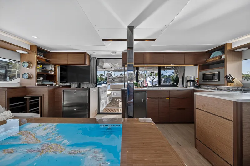 Slide: The Image of Luxurious interior of 2021 Lagoon 46 Owner's Version yacht with modern kitchen and navigation table. - 55