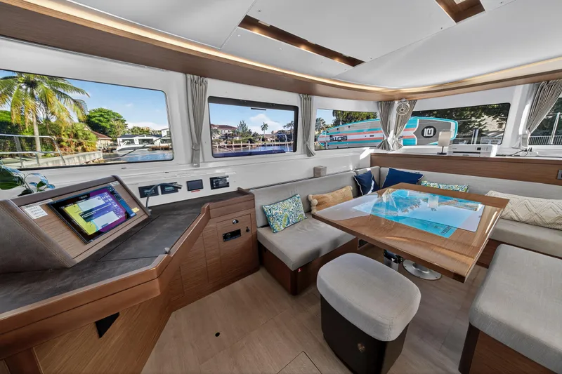 Slide: The Image of Luxurious interior of 2021 Lagoon 46 Owner's Version catamaran with modern seating and navigation station. - 57