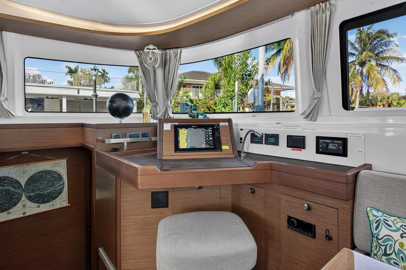 Slide: The Image of Interior of 2021 Lagoon 46 Owner's Version yacht with navigation station and panoramic windows. - 59