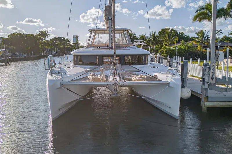 Slide: The Image of 2021 Lagoon 46 Owner's Version catamaran docked in a sunny marina setting. - 6