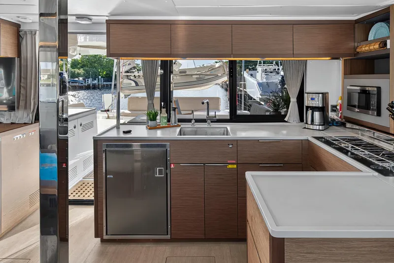 Slide: The Image of Modern kitchen interior of 2021 Lagoon 46 Owner's Version yacht, featuring sleek appliances and waterfront view. - 63