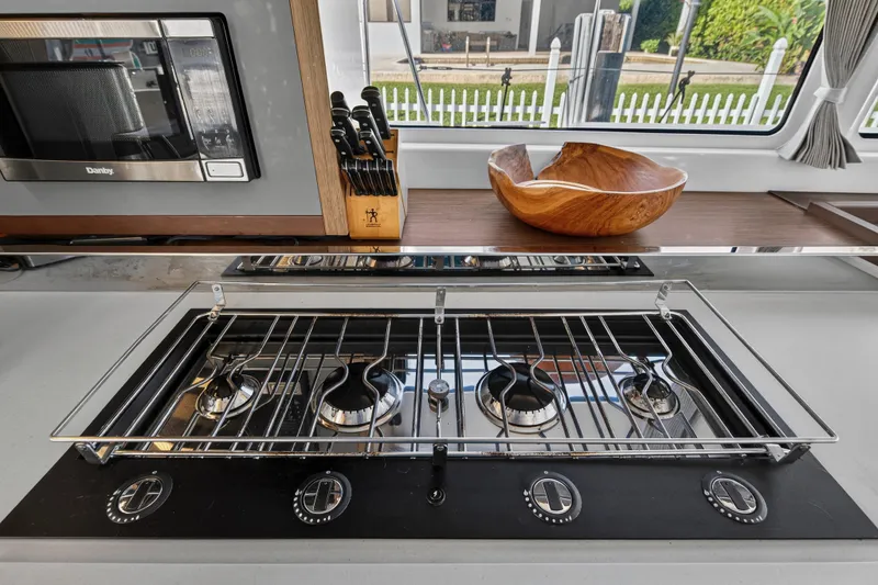 Slide: The Image of Modern kitchen in 2021 Lagoon 46 yacht with stove, microwave, and wooden bowl. - 67