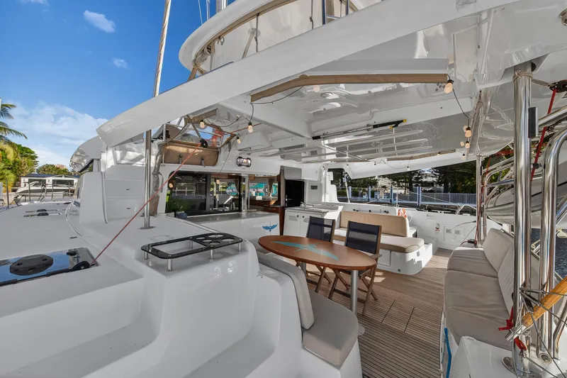 Slide: The Image of 2021 Lagoon 46 Owner's Version catamaran with spacious outdoor seating and dining area. - 7