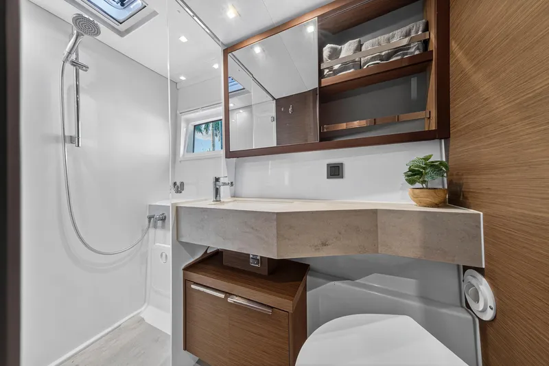 Slide: The Image of Modern bathroom in 2021 Lagoon 46 Owner's Version yacht, featuring sleek design and wood accents. - 90
