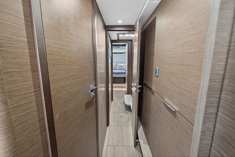 Slide: The Image of Interior hallway of 2021 Lagoon 46 Owner's Version yacht, featuring modern wood paneling. - 96