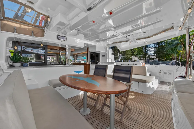 Slide: The Image of Spacious interior of 2021 Lagoon 46 Owner's Version catamaran with elegant seating and wooden table. - 10