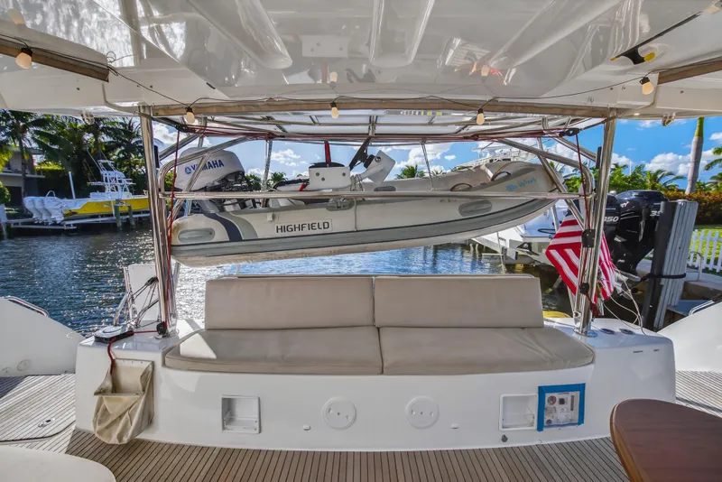 Slide: The Image of Lagoon 46 Owner's Version 2021 yacht with dinghy and American flag at marina. - 11